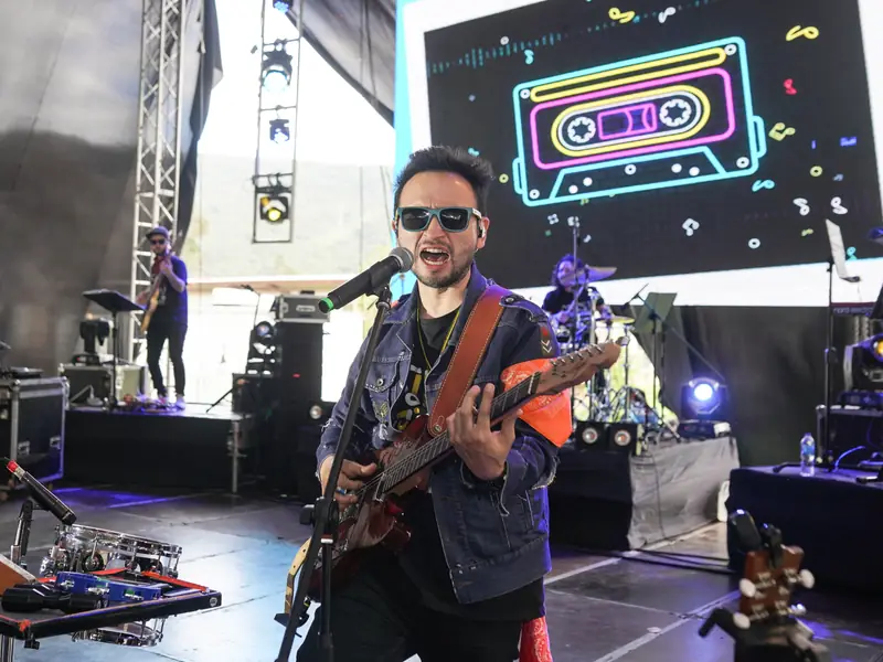 Músico con guitarra en el escenario de la clausura de la DIAN