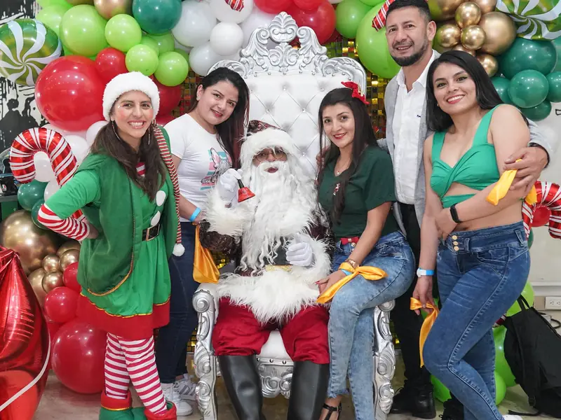 Empleados de Eurofarma posando con Papá Noel y una elfa en su fiesta de Navidad